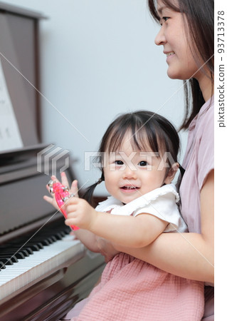 1 year old girl and mom playing upright piano 93713378