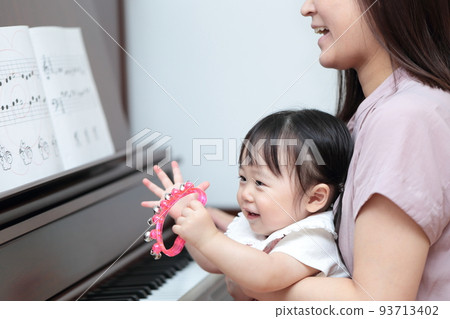 1 year old girl and mom playing upright piano 93713402