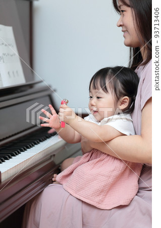 1 year old girl and mom playing upright piano 93713406
