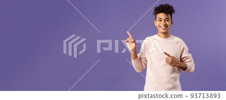 Portrait of cheerful, healthy smiling man pointing fingers upper left corner, recommending buy product, shop online, order delivery, advertisement and people concept, purple background 93713893