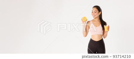 Sport, wellbeing and active lifestyle concept. Portrait of smiling healthy and slim asian girl advice eating healthy food for breakfast, gain energy for workout, hold fresh juice and orange Sport, wellbeing and active lifestyle concept. Portrait of smiling healthy and slim asian girl advice eating healthy food for breakfast, gain energy for workout, hold fresh juice and orange 93714210