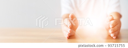 Insurance concept. Light between man hands in gesture of protection and blank space Insurance concept. Light between man hands in gesture of protection and blank space 93715755