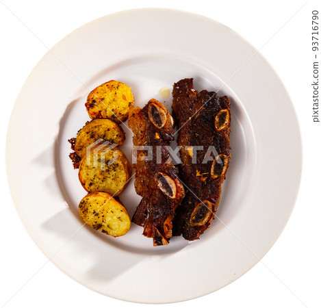 Spanish cuisine churrasco de ternera, spare ribs with potatoes on white ceramic plate Spanish cuisine churrasco de ternera, spare ribs with potatoes on white ceramic plate 93716790