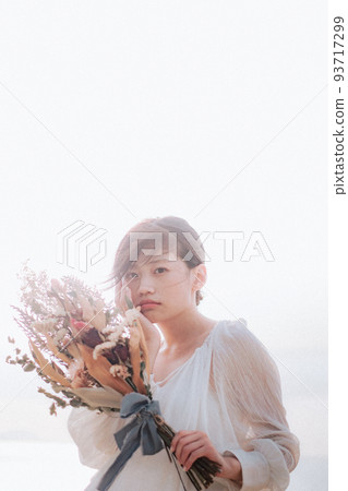 Woman with a bouquet on the beach Woman with a bouquet on the beach 93717299