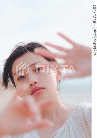 Woman hiding her face on the beach Woman hiding her face on the beach 93717504