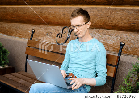 Middle aged man choosing a gift online using laptop Middle aged man choosing a gift online using laptop 93720986