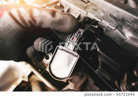 The auto mechanic is unplugging the ignition coil 93721044