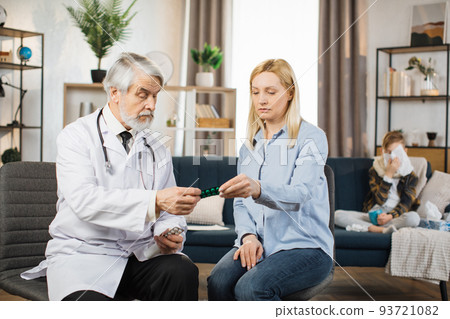 Doctor consulting worried middle aged blond mother about her sick son's treatment Doctor consulting worried middle aged blond mother about her sick son's treatment 93721082