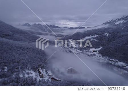 Aerial view of the mountains range with clouds and storm clouds in twilight. Caucasus Mountains, Plateau Lago-Naki. Aerial view of the mountains range with clouds and storm clouds in twilight. Caucasus Mountains, Plateau Lago-Naki. 93722248
