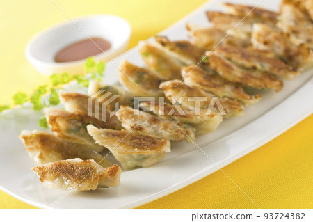 Bite-sized gyoza dumplings served on a plate 93724382
