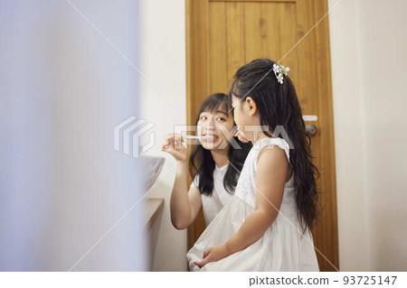 A young mother performing oral care for her child A young mother performing oral care for her child 93725147