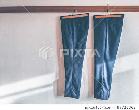 Men's trousers hanging on the wall 93725365