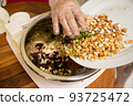 Female hands making dough for mooncake, homemade cantonese moon cake pastry on baking tray before baking for traditional festival. Travel, holiday, food concept 93725472