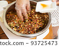 Female hands making dough for mooncake, homemade cantonese moon cake pastry on baking tray before baking for traditional festival. Travel, holiday, food concept 93725473