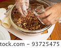 Female hands making dough for mooncake, homemade cantonese moon cake pastry on baking tray before baking for traditional festival. Travel, holiday, food concept 93725475
