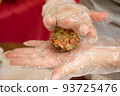 Female hands making dough for mooncake, homemade cantonese moon cake pastry on baking tray before baking for traditional festival. Travel, holiday, food concept 93725476
