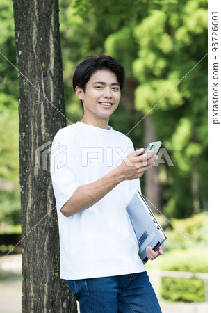 A man holding a smartphone in one hand outdoors A man holding a smartphone in one hand outdoors 93726001
