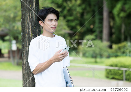 一個男人在戶外一隻手拿著智能手機 93726002