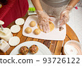 Female hands making dough for mooncake, homemade cantonese moon cake pastry on baking tray before baking for traditional festival. Travel, holiday, food concept 93726122