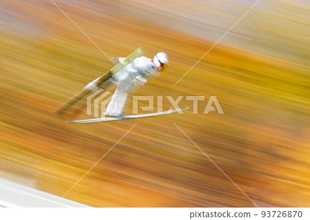 Panning shot of autumn leaves and ski jumpers 93726870