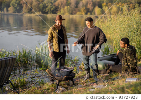 Multiracial friends having a picnic on fishing Multiracial friends having a picnic on fishing 93727928