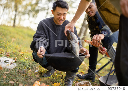 Man put big fish in cauldron for cooking Ukha soup Man put big fish in cauldron for cooking Ukha soup 93727948
