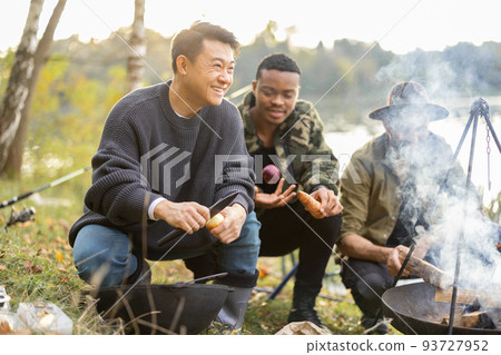 Multiracial friends having a picnic on fishing Multiracial friends having a picnic on fishing 93727952