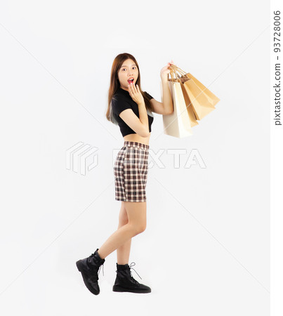 Young asian woman in black crop t-shirt carrying brown paper shopping bags, full body posing on white background. 93728006