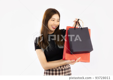 Young asian woman long hair in black t-shirt carrying and holding black and red paper shopping bags on white background. Young asian woman long hair in black t-shirt carrying and holding black and red paper shopping bags on white background. 93728011