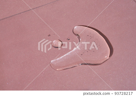 A drop of cosmetics or perfume on a pink background. A drop of cosmetics or perfume on a pink background. 93728217