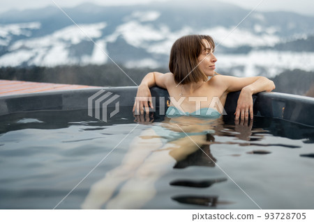 Woman bathing in hot tub at mountains Woman bathing in hot tub at mountains 93728705