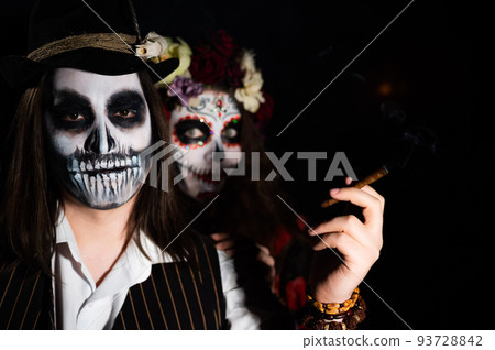 Man and woman in paired halloween costumes. Body art santa muerte and skeleton Man and woman in paired halloween costumes. Body art santa muerte and skeleton 93728842