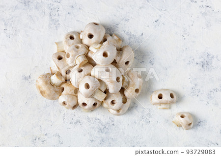 A bunch of raw champignon mushrooms in the form of skulls. Edible Halloween Concept A bunch of raw champignon mushrooms in the form of skulls. Edible Halloween Concept 93729083