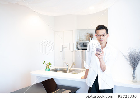 A man collects information on his smartphone while promoting blood flow while working in the dining room 93729336