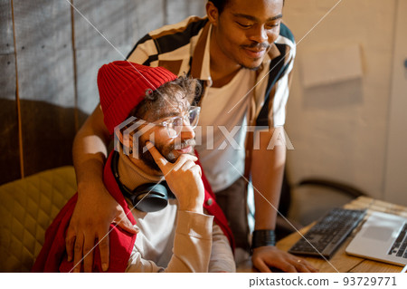 Gay couple working on computers at home office Gay couple working on computers at home office 93729771