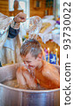 Priest pours water on the child at christening. Happy child during the rite of christening 93730022