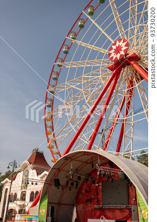 Round ferris wheel spins fast at colorful day 93730200
