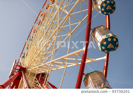 Round ferris wheel spins fast at colorful day 93730201