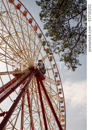 Round ferris wheel spins fast at colorful day 93730202