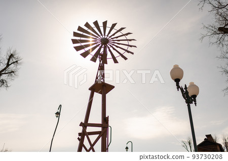 old wind turbine with blades on cloudy sky background 93730208