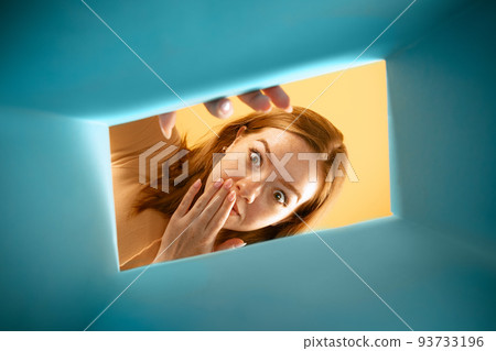 Beautiful young exressive girl opening, unpacking carton box and looking inside. Emotions, black friday, holidays, online shopping concept Beautiful young exressive girl opening, unpacking carton box and looking inside. Emotions, black friday, holidays, online shopping concept 93733196