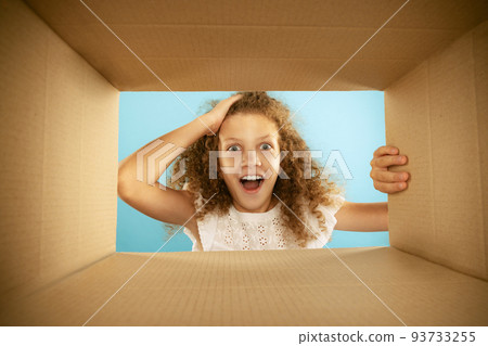 Emotional kid, little girl looking inside box during opening, unpacking it. Emotions, black friday, holidays, online shopping concept Emotional kid, little girl looking inside box during opening, unpacking it. Emotions, black friday, holidays, online shopping concept 93733255