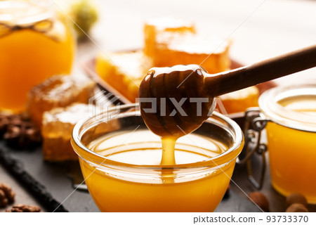 Honey on wooden honey-dipper closeup food background 93733370