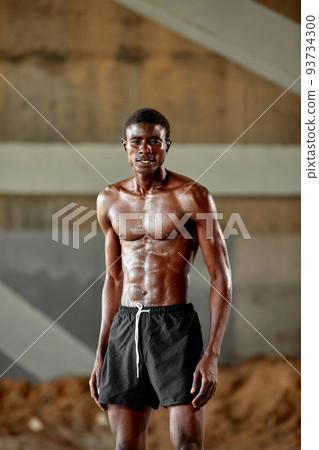 Handsome African American sportman standing on the street while taking break after training. Black male having rest after workout Handsome African American sportman standing on the street while taking break after training. Black male having rest after workout 93734300