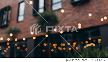 Decorative outdoor string lights at night time, Defocused Background, night city life backdrop, party time with Yellow bokeh balls Decorative outdoor string lights at night time, Defocused Background, night city life backdrop, party time with Yellow bokeh balls 93734717