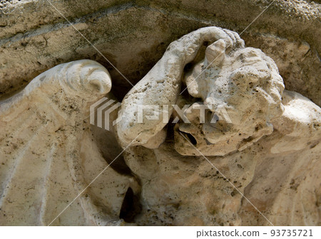Eroded building stone statue close-up of an angel. 93735721