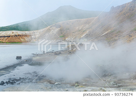 boiling and steaming hydrothermal outlet on the shore of the hot lake in the caldera of the Golovnin volcano on the island of Kunashir boiling and steaming hydrothermal outlet on the shore of the hot lake in the caldera of the Golovnin volcano on the island of Kunashir 93736274