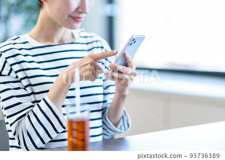 在咖啡館操作智能手機的中年婦女（部分） 93736389