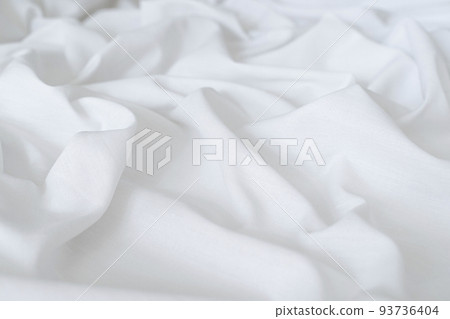 White drapery linen fabric background. Texture of the light surface of the fabric. White drapery linen fabric background. Texture of the light surface of the fabric. 93736404