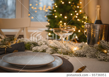 Christmas festive table setting, gold decorate and champagne. Family holiday dinner or New Year party. Christmas festive table setting, gold decorate and champagne. Family holiday dinner or New Year party. 93736951